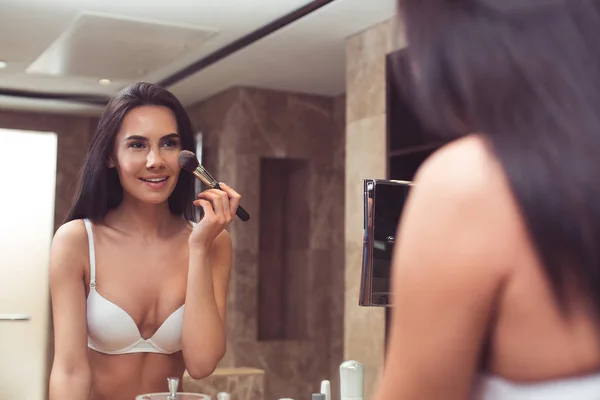 Mooie vrouw, doet make-up in ondergoed — Stockfoto