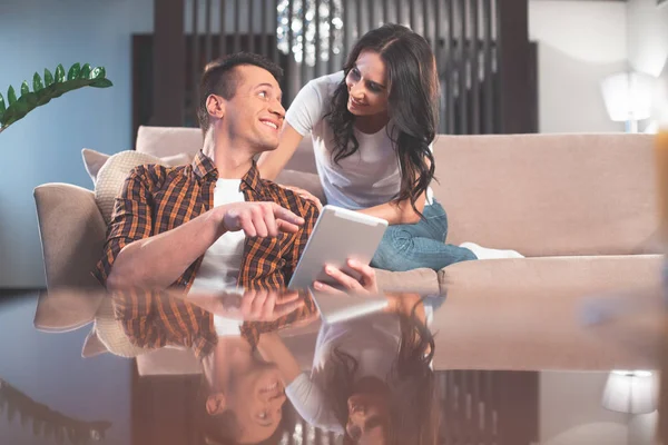 Felice uomo e donna utilizzando tablet in soggiorno — Foto Stock