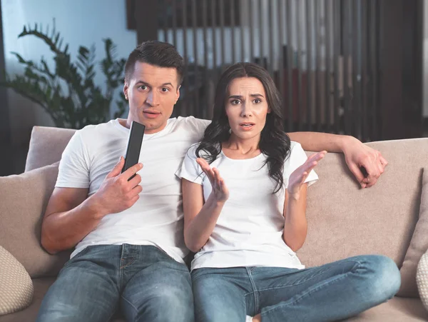 Pasangan yang terkejut menonton TV di apartemen — Stok Foto