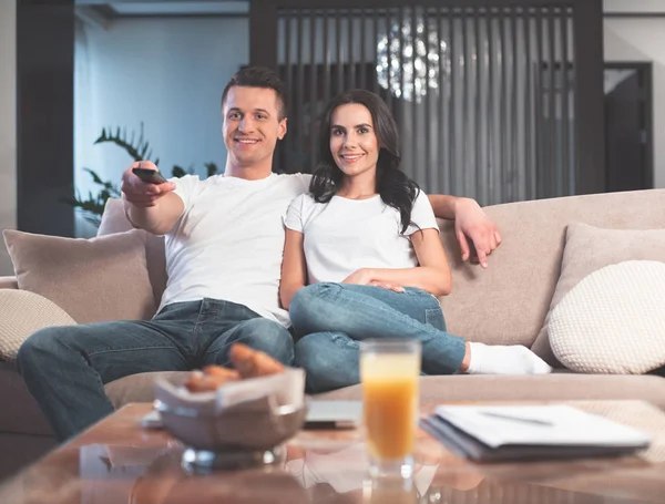 Allegro giovane uomo e donna che guardano la TV insieme — Foto Stock