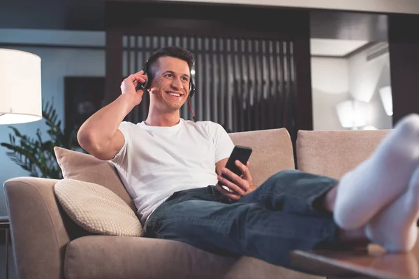 Joven despreocupado escuchando música en el salón — Foto de Stock