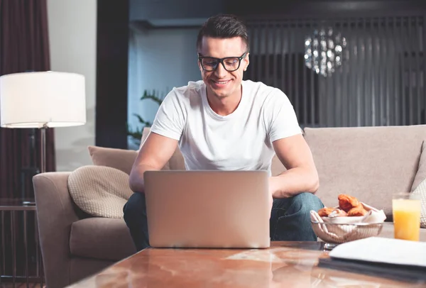 Joven alegre usando la computadora para el trabajo independiente — Foto de Stock