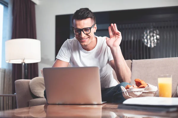 Amistoso joven que habla en Internet a través de la computadora portátil — Foto de Stock