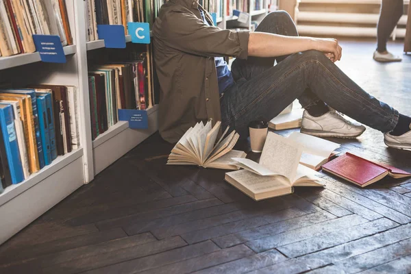 Man zoeken in de buurt van de boekenplank in Atheneum — Stockfoto