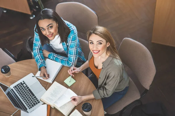 Positieve vrouwen kijken door volume — Stockfoto