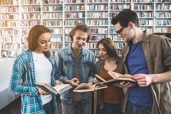 Εξερχόμενες groupmates ανάγνωση βιβλίων στη βιβλιοθήκη — Φωτογραφία Αρχείου