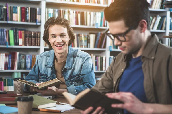 Zufriedene Freunde lernen in der Bibliothek — Stockfoto