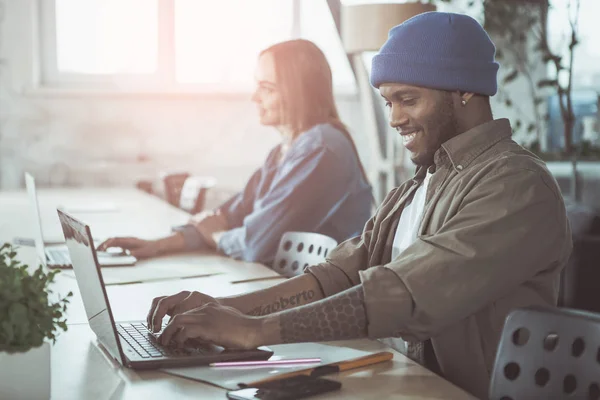 Vrolijke man is modern apparaat gebruiken in office — Stockfoto