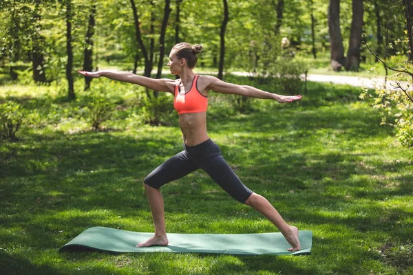 Femme souriante pratique le yoga en plein air — Photo