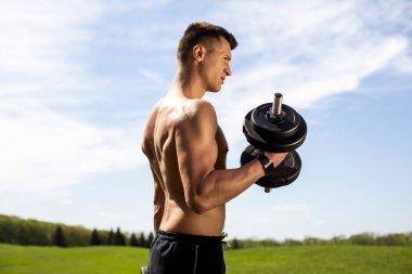 Kaslı erkek doğa eğitim kollarında konsantre olması