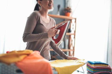 Neşeli kadın ütü temiz giysiler