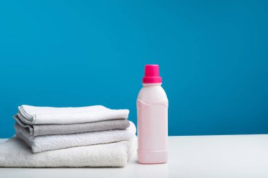 Yumuşatıcı bir şişe katlanmış banyo havlusu