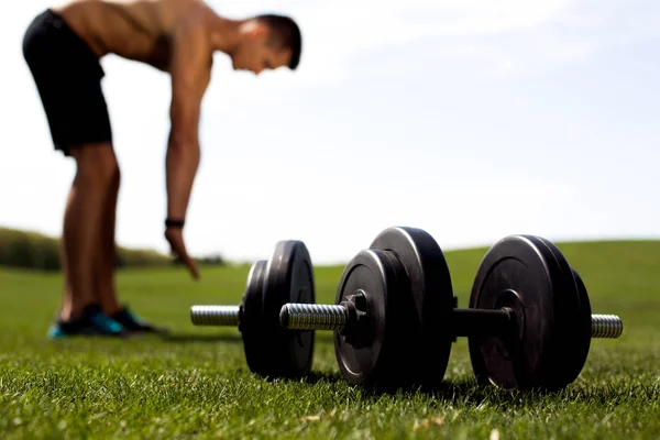 Esportista está se alongando durante o exercício com peso fora — Fotografia de Stock