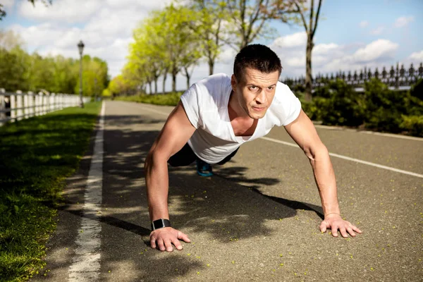 Rippade man utövar på bröstmusklerna i naturen — Stockfoto