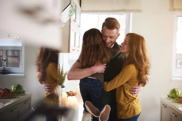 Madre e padre coccole figlia in cucina — Foto Stock