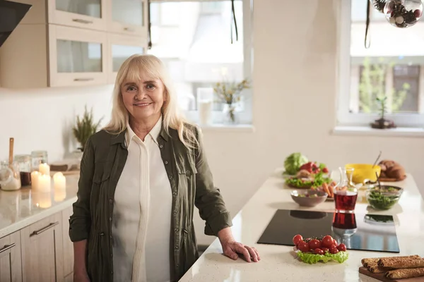 Senior female standing in kitchen with smile — Stock Photo, Image