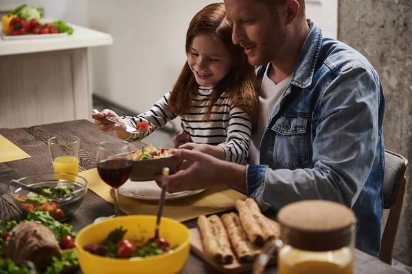 Gülümseyen baba ve kız akşam yemeği yeme