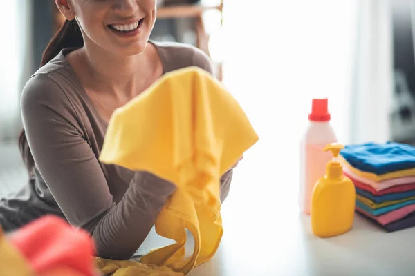 Mulher satisfeita segurando camiseta amarela — Fotografia de Stock