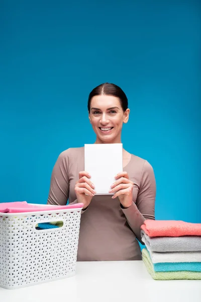 Mulher feliz mostrando o melhor detergente para lençóis — Fotografia de Stock