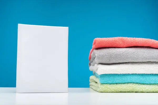 Toalhas coloridas fofas e detergente na placa branca — Fotografia de Stock