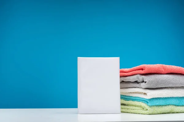 Mesa de lavandaria com detergentes e roupa de cama limpa — Fotografia de Stock