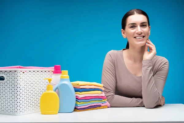 Dona de casa feliz a bordo com roupas e detergentes — Fotografia de Stock