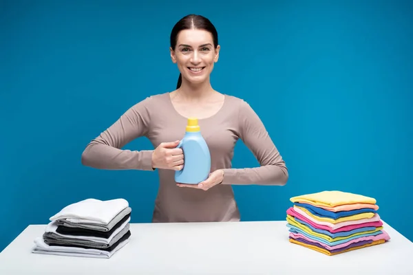 Mulher sorridente com detergente para roupa — Fotografia de Stock