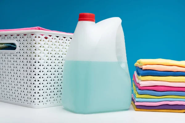 Jar of detergent standing with clean clothes — Stock Photo, Image