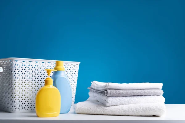 Cesta para lençóis e líquidos de lavandaria em tábua de madeira — Fotografia de Stock