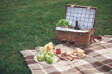 Lezzetli yiyecek ve piknik sepeti'nın bahçesinde yakınındaki kadehlerin 