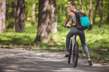 Genç kadın ormandan bisikletle seyahat ediyor