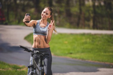 Sırıtan atletik kız güneşli parkta ateş ediyor