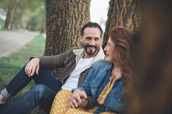 Pozitivní muž a žena odpočívat na trávě u silnice — Stock fotografie