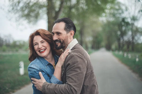 Cheerful middle-aged man and woman dating in the park