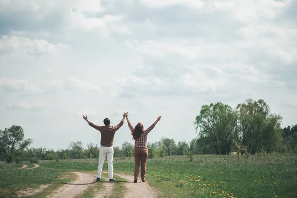 Pareja feliz disfrutando de la naturaleza en el pastizal — Foto de Stock