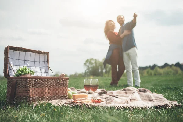 Boldog férfi és nő birtoklás piknik a legelőn — Stock Fotó