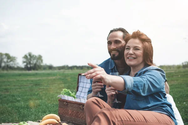 Vrolijke verliefde paar bewonderen van de natuur op het grasland — Stockfoto