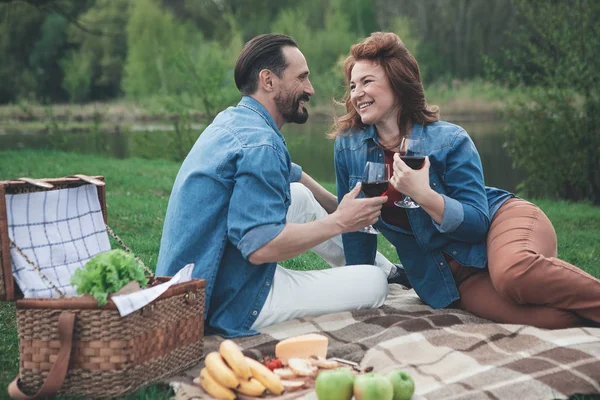 Fröhliche Eheleute beim Picknick am Wasser — Stockfoto