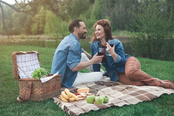 Örömteli férfi és a nő iszik bort folyó közelében — Stock Fotó