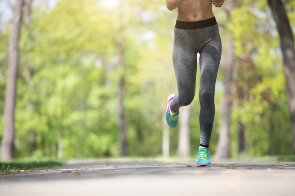 Athletic woman is jogging through wood — Stock Photo, Image