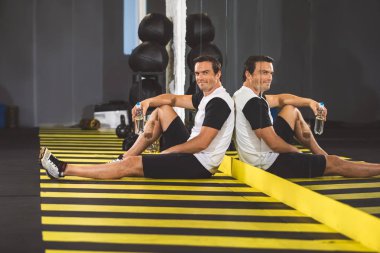 Neşeli adam rahatlatıcı spor salonunda katta