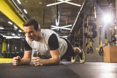 Spor salonunda statik egzersiz yaparak mutlu adam