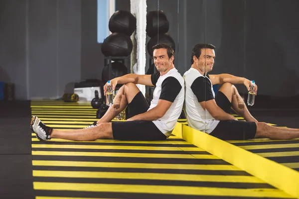 Neşeli adam rahatlatıcı spor salonunda katta