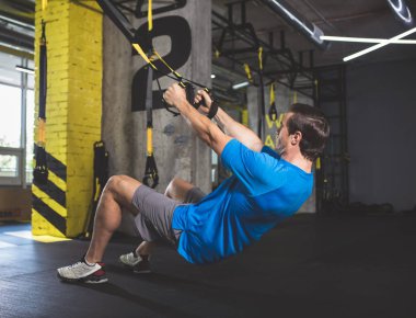 Sakin erkek süspansiyon kablosuyla egzersiz yapıyor