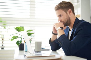 Bilgisayar başında oturan düşünceli işadamı