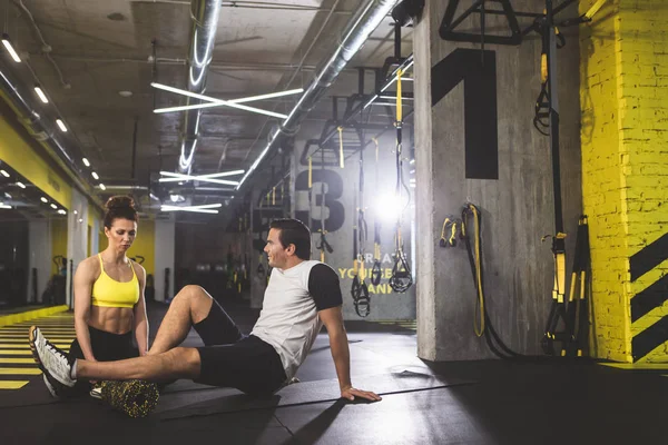 Hombre feliz haciendo ejercicio con el instructor — Foto de Stock