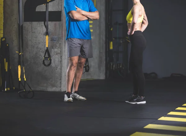 Femmina e uomo piedi localizzando in palestra — Foto Stock