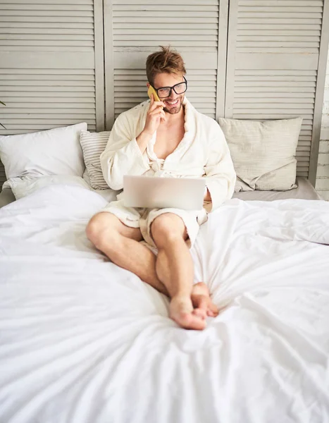 Hombre alegre hablando por teléfono en la cama — Foto de Stock