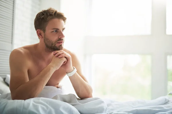 Aantrekkelijke nadenkende man overweegt regelingen na het wakker worden — Stockfoto