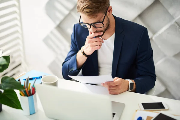 Koncentrerad affärsman läser dokument i ämbetet — Stockfoto